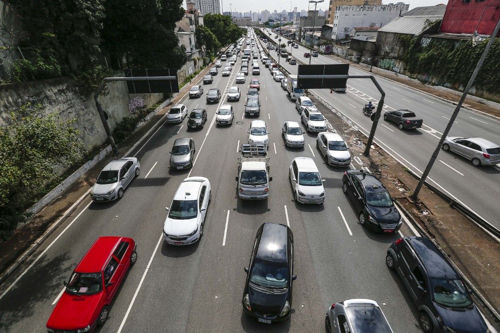 Venda de veículos no Brasil avança 12% Veículos transitam por avenida em São Paulo