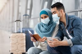 Muslim,Couple,In,Medical,Masks,Waiting,For,Flight,In,Airport