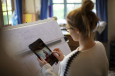 Architect video chatting and working at drafting table