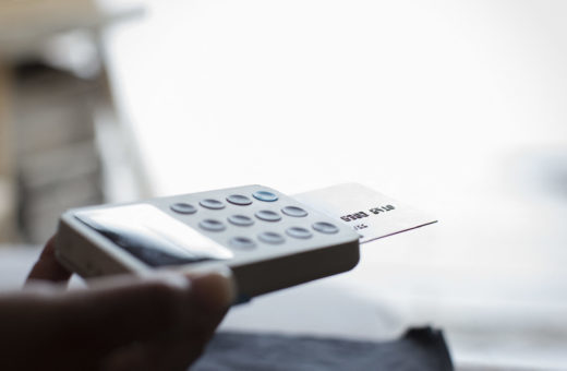Close up shop owner holding credit card reader