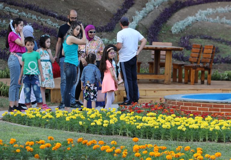 visitors are pictured during the opening of the 42nd International Flower Show in the Tishreen park in the capital Damascus on June 22, 2022. (Photo by LOUAI BESHARA / AFP)