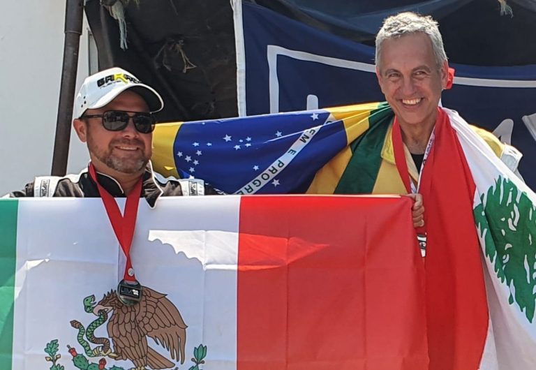 Two men holding the flags of Mexico, Brazil and Lebanon after powerboat competition