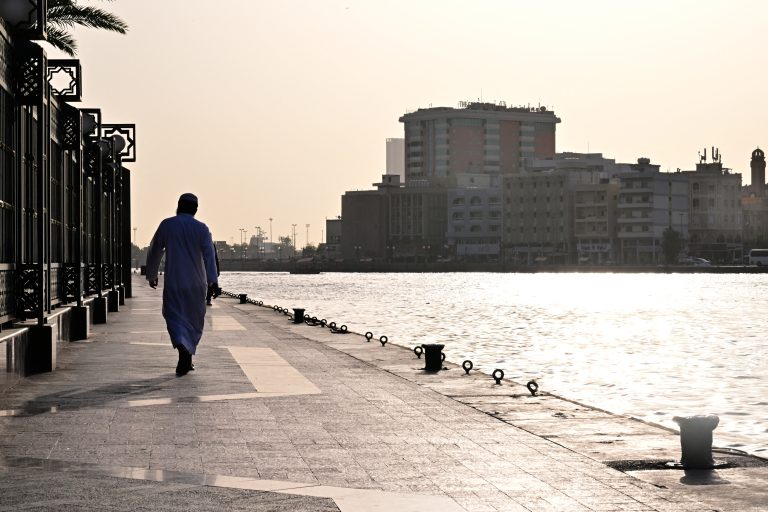 A man walks along the waterside in Bur Dubai on May 15, 2024. (Photo by Giuseppe CACACE / AFP)