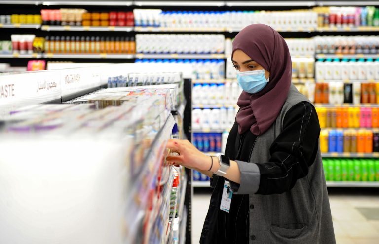 Funcionária arruma prateleiras de uma loja LuLu em Jeddah durante a pandemia