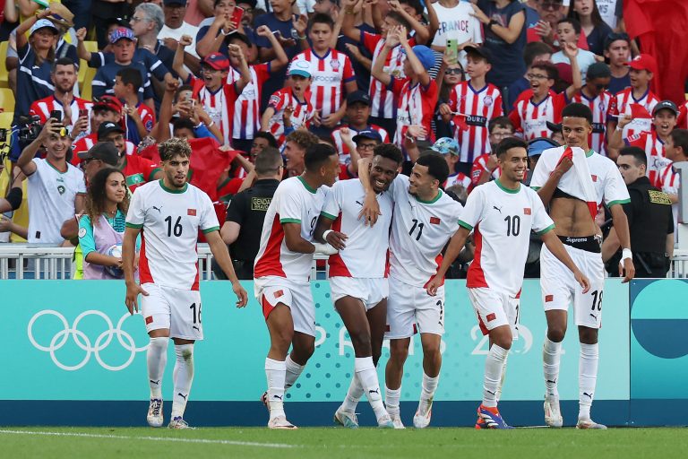 لاعبي المنتخب المغربي خلال احتفالهم بتسجيلهم لإحدى الأهداف خلا مواجهتهم للمنتخب المصري: هذه الميدالية هي الأولى التي تفوز بها المغرب في منافسات اللعب الجماعي في تاريخ الأولمبيات.