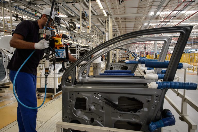 A man works on the production line of the March and Versa models at Nissan's Industrial Complex in Resende, 160 km west of Rio de Janeiro, Brazil, on Februrary 3, 2015. The Nissan plant in Brazil will be able to produce 200,000 cars and utility vehicles per year. The company aims to achieve 5 percent of the market share by 2016 in Brazil, the fourth largest automotive market in the world. AFP PHOTO / YASUYOSHI CHIBA (Photo by Yasuyoshi CHIBA / AFP)