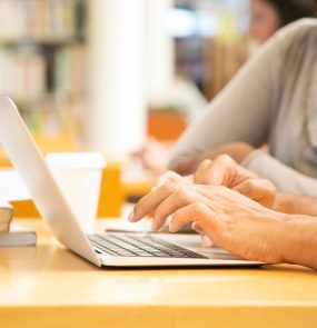 Closeup shot of female hands typing on laptop
