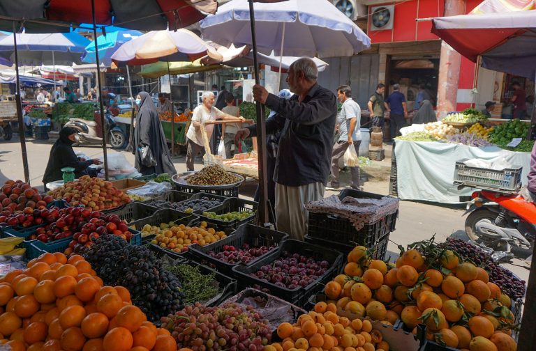 People gather at Al-Sadriya Market in the Iraqi capital Baghdad, known for its fresh fruit and vegetable stands, on July 9, 2020. Iraq, in a bid to prevent the spread of the deadly COVID-19 pandemic, shut its 32 border crossings to goods and people coming from Iran, Turkey, Syria, Jordan and Saudi Arabia in mid-March.