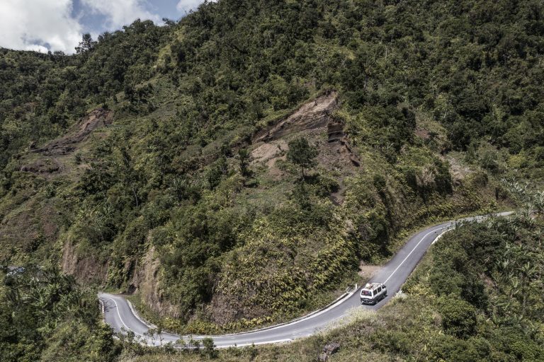 National groups unite for forests in Comoros This aerial view shows a collective taxi bus climbs a steep road near a deforested patch on a mountain side in Tsembehou, on July 23, 2025. The majority of the country's approximately 10,000 producers of ylang-ylang, the pricey flower sought after by perfumers around the world of which the Comoros has long been the world leader, are located in this territory. Wood remains the least expensive source of energy to this day but Comoros lost 80% of our natural forests between 1995 and 2014. The phenomenon of deforestation is intensified by very strong demographic pressure. Farmers are looking for arable land for their activities. (Photo by MARCO LONGARI / AFP)