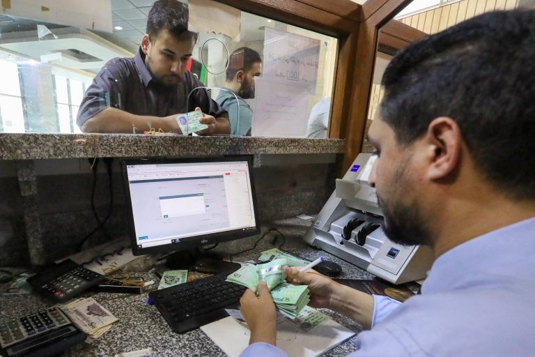 موظف في إحدى المصارف يعد نقوداً في إحدى الوكالات في مدينة مصراتة الليبية: ضخ أموال في النظام المالي