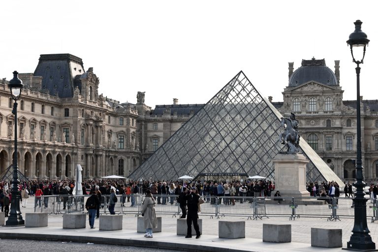 Visitors queue in front of the Pyramide du Louvre, designed by Chinese-US architect Ieoh Ming Pei, with the Louvre Museum in the background in Paris on October 22, 2025. The Louvre Museum reopened its doors to visitors on October 22, 2025 morning for the first time since October 19, 2025's spectacular robbery by four criminals, who made off with eight jewels worth an estimated 88 million, an AFP journalist reported. (Photo by Thibaud MORITZ / AFP)