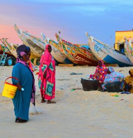 MAURITANIA. NOUAKCHOTT. WOMEN IN MELHFA WAITING FOR THE RETURN OF THE FISHERMEN NEAR THE FISH MARKET OF NOUAKCHOTT.