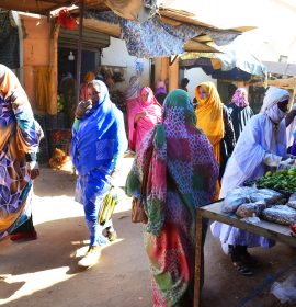 MAURITANIA. ATAR. WOMEN IN THE MARKET DRESSED WITH THEIR MELHFA, A COLORFULL VAIL.