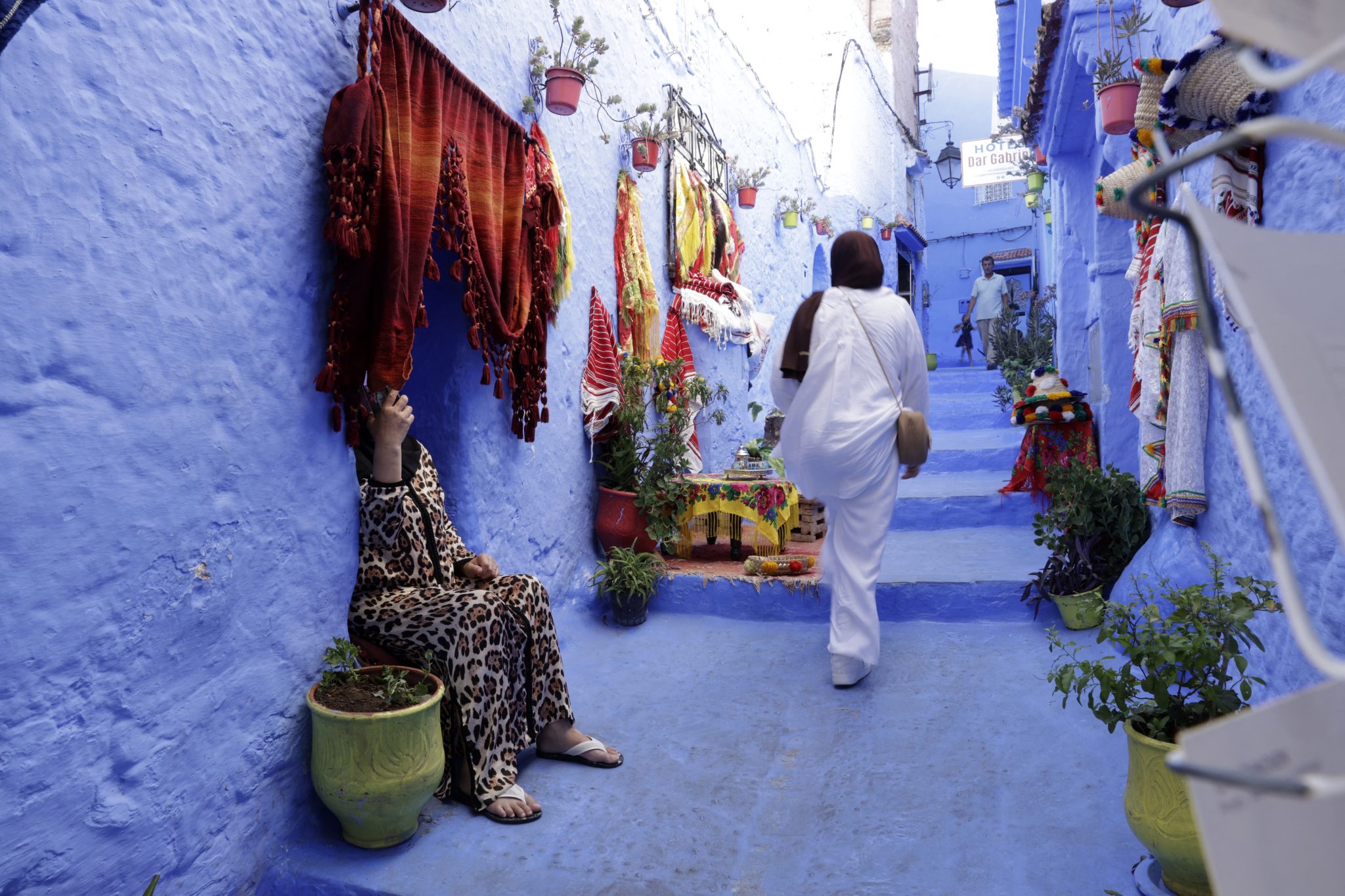 A woman walks up the stairs in the Medina of the northwestern Moroccan city of Chefchaouen on August 14, 2025, known for its buildings in shades of blue. (Photo by Abdel Majid BZIOUAT / AFP)
