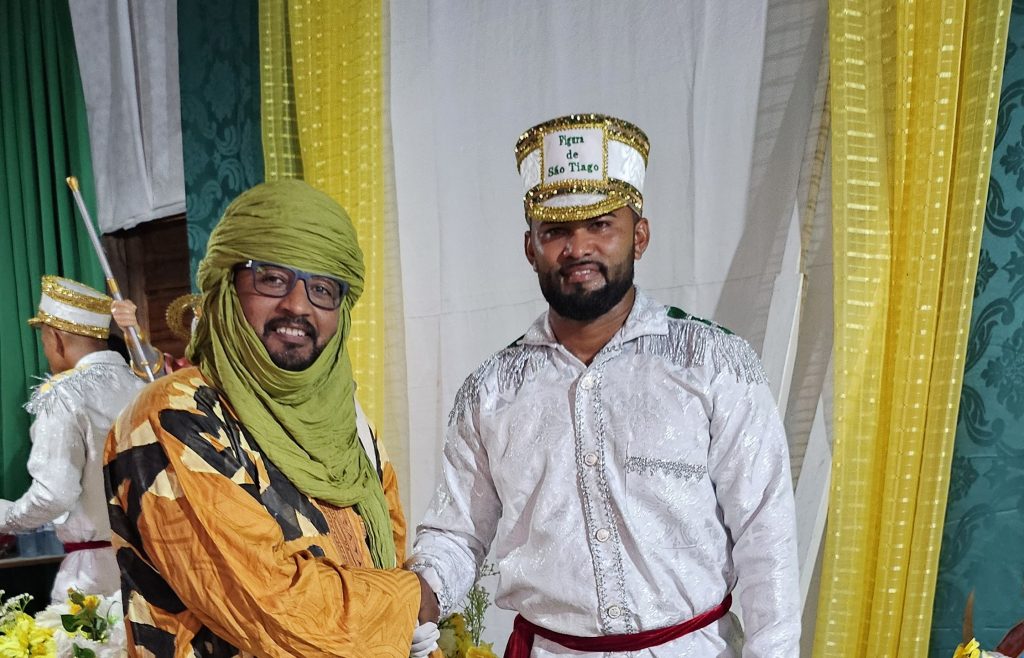 Pesquisador Adnane Mahfouz com morador que interpretou São Tiago na festa de 2026